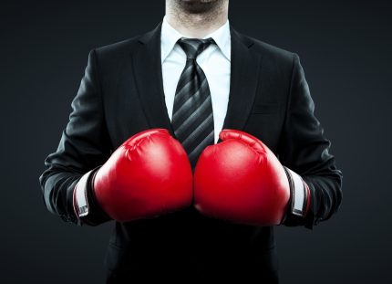 Business man wearing red boxing gloves
