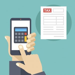 Hand holding smartphone with calculator on screen and tax form. Tax calculator, mobile app for accounting concepts. Making Tax Digial (MTD)