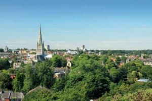 A photo taken from Mousehold Heath on a Summer's day in the city of Norwich. The image shows many landmarks including the Cathedral, The Forum, City Hall and the Roman Catholic Cathedral.